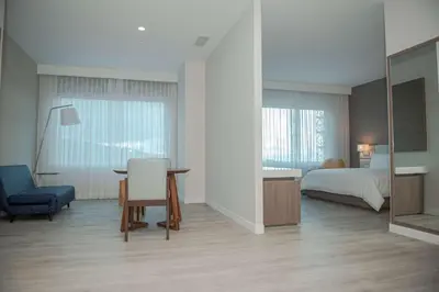 a bedroom with a bed and a table and a chair at Hilton Garden Inn Santa Ana, San Jose in San José