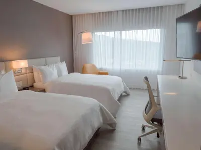 a hotel room with two beds and a window at Hilton Garden Inn Santa Ana, San Jose in San José