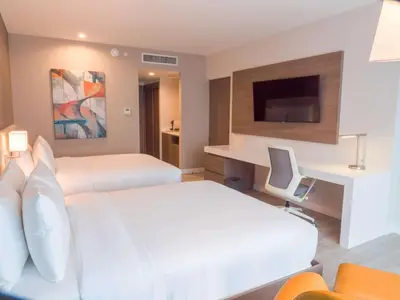 a hotel room with two beds and a desk at Hilton Garden Inn Santa Ana, San Jose in San José