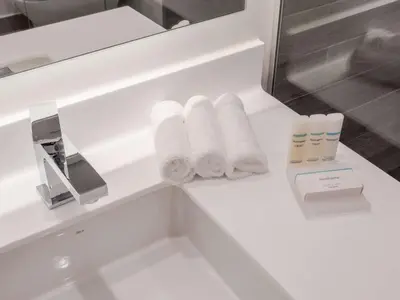 a bathroom counter with towels and a sink at Hilton Garden Inn Santa Ana, San Jose in San José