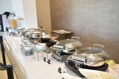 a buffet line with many pots and pans on display at Hilton Garden Inn Santa Ana, San Jose in San José