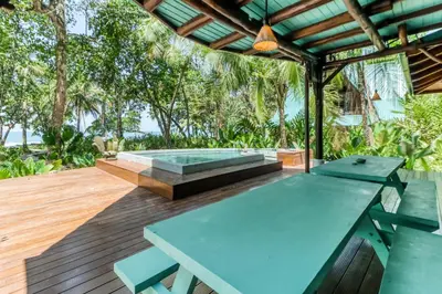 a patio with a picnic table and a bench at El Ballenato de Bahia in Uvita