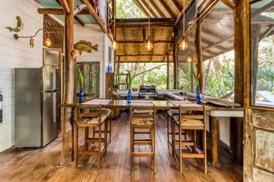 a kitchen with a long wooden table and chairs at El Ballenato de Bahia in Uvita