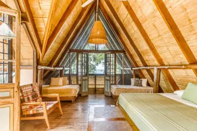 a bedroom in a tree house with a large window at El Ballenato de Bahia #2 in Uvita
