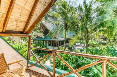 a view from the balcony of a house with palm trees at El Ballenato de Bahia #2 in Uvita