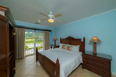 a bedroom with a bed with a ceiling fan and a window at Del Mar 3C 3 bdr Ocean View in Los Suenos in Herradura