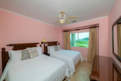 two beds in a room with pink walls at Del Mar 3C 3 bdr Ocean View in Los Suenos in Herradura