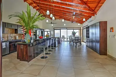 a large kitchen with a dining room and a dining table at Stunning Casa de la Roca House with Infinity Pool! in Ojochal