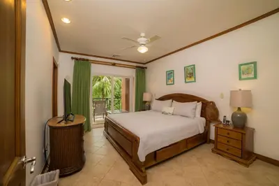 a bedroom with a bed and a tv in it at Veranda 1C 3 bdr Golf Course View in Los Suenos in Herradura