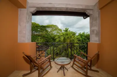 a balcony with two chairs and a table and a window at Veranda 1C 3 bdr Golf Course View in Los Suenos in Herradura