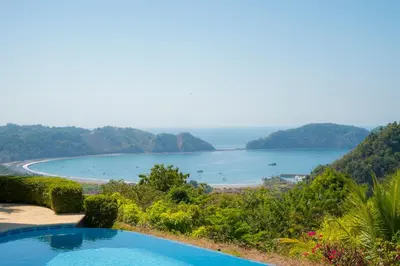 a view of a lake from a resort with a swimming pool at Puesta del Sol 5 bdrs ocean view in Los Suenos in Herradura