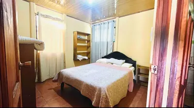 a small bedroom with a bed in a room at Casa con vista a valle de Dota y zona cafetalera in Santa María