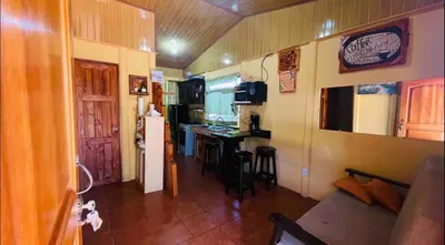 a living room with a couch and a kitchen at Casa con vista a valle de Dota y zona cafetalera in Santa María