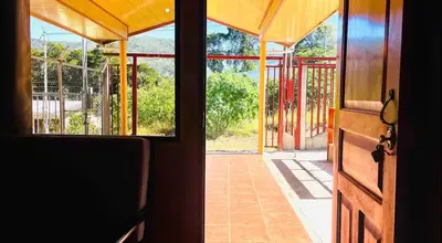 an open door of a house with a view of a porch at Casa con vista a valle de Dota y zona cafetalera in Santa María