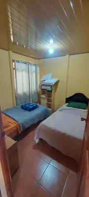 a bedroom with two beds in a room at Casa con vista a valle de Dota y zona cafetalera in Santa María