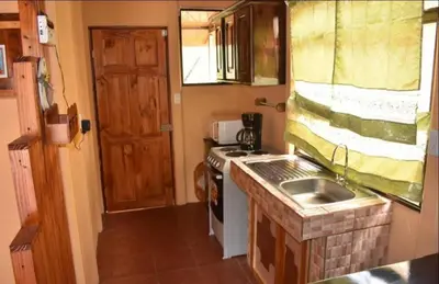 a small kitchen with a sink and a stove at Casa con vista a valle de Dota y zona cafetalera in Santa María