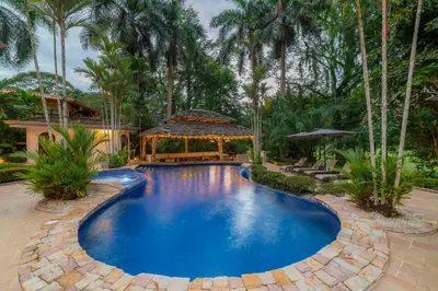 a swimming pool in a backyard with a gazebo at Harmon Estate 6 bdrs private pool in Los Suenos in Herradura