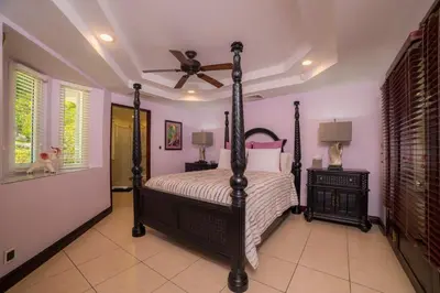 a bedroom with a bed and a ceiling fan at Harmon Estate 6 bdrs private pool in Los Suenos in Herradura