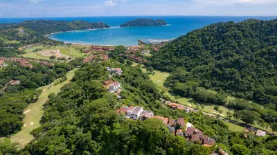an aerial view of a house on a hill next to the ocean at Harmon Estate 6 bdrs private pool in Los Suenos in Herradura