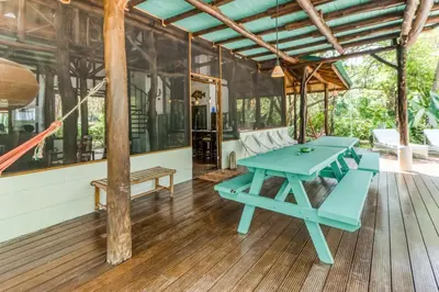 a picnic table on the porch of a house at El Ballenato de Bahia Whole House in Uvita