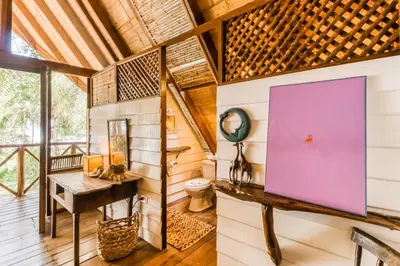 a room in a tree house with a purple screen on the wall at El Ballenato de Bahia Whole House in Uvita