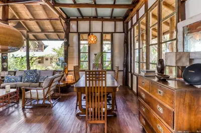 a dining room with a wooden table and chairs at El Ballenato de Bahia Whole House in Uvita