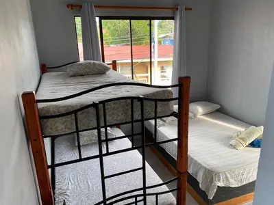 a bunk bed in a room with a window at Hotel Pacuare Turrialba in Turrialba