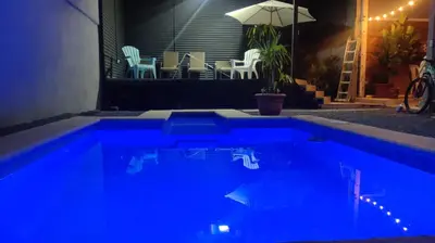 a large blue pool with chairs and an umbrella at Hotel Pacuare Turrialba in Turrialba
