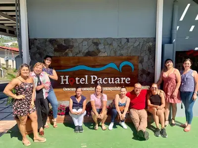a group of people posing for a picture in front of a sign at Hotel Pacuare Turrialba in Turrialba