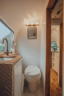 a small bathroom with a toilet and a sink at Airstream by the Sea in Nosara