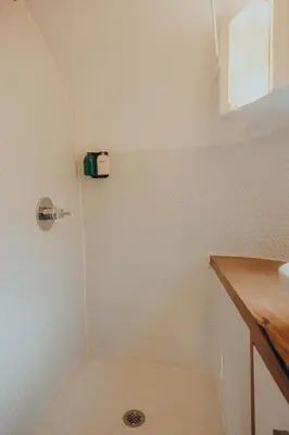 a small bathroom with a shower with a sink at Airstream by the Sea in Nosara
