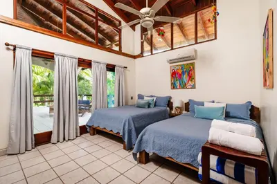a bedroom with two beds and a ceiling fan at Casa Sueca Hotel - At the Beach in Tamarindo