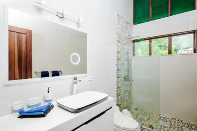 a white bathroom with a toilet and a shower at Casa Sueca Hotel - At the Beach in Tamarindo
