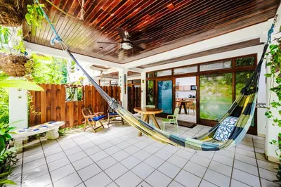 a porch with a hammock in a house at Casa Sueca Hotel - At the Beach in Tamarindo