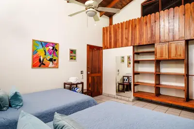 a bedroom with two beds and a ceiling fan at Casa Sueca Hotel - At the Beach in Tamarindo