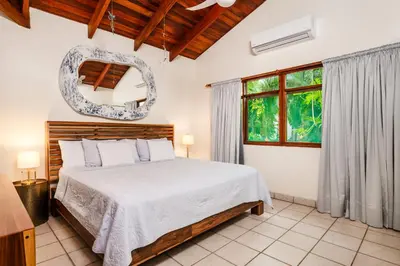 a bedroom with a bed and a window at Casa Sueca Hotel - At the Beach in Tamarindo