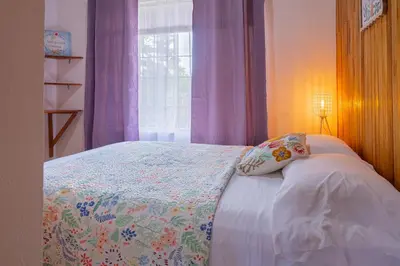 a bedroom with a bed with a pillow and a window at Beautiful Casa Aire near Lake Arenal in Nuevo Arenal - Casas Airelibre in Nuevo Arenal