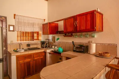 a kitchen with wooden cabinets and a counter top at Beautiful Casa Aire near Lake Arenal in Nuevo Arenal - Casas Airelibre in Nuevo Arenal