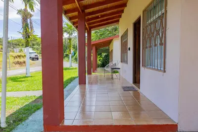 a porch of a building with a chair on it at Beautiful Casa Aire near Lake Arenal in Nuevo Arenal - Casas Airelibre in Nuevo Arenal