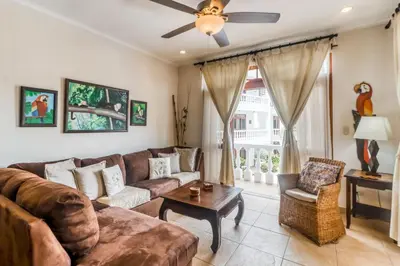 a living room with a couch and a ceiling fan at La Paloma Blanca D2 in Jacó
