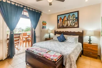 a bedroom with a bed and a dining room at La Paloma Blanca D2 in Jacó