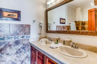 a bathroom with a sink and a mirror at La Paloma Blanca D2 in Jacó