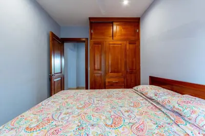 a bedroom with a bed and a wooden cabinet at 2 Bedroom Ocean-View Condo with Pool in Playa Flamingo
