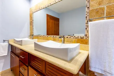 a bathroom with a large sink and a mirror at 2 Bedroom Ocean-View Condo with Pool in Playa Flamingo