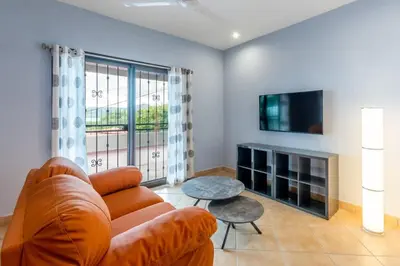 a living room with a couch and a tv at 2 Bedroom Ocean-View Condo with Pool in Playa Flamingo