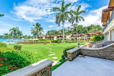 a view of the resort from the garden at Spacious Open-Concept Condo with Stylish Design, Direct Beach Access & Resort-Style Amenities in Playa Flamingo