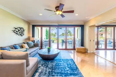 a living room with a couch and a ceiling fan at Spacious Open-Concept Condo with Stylish Design, Direct Beach Access & Resort-Style Amenities in Playa Flamingo