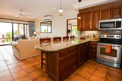 a kitchen with a counter top and a living room at Elegant 3BR Beachfront Condo with Spacious Interior, Ocean-View Terrace & Direct Access to Playa Flamingo in Playa Flamingo