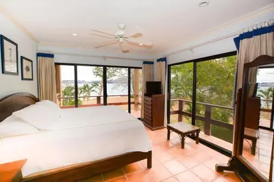 a bedroom with a large bed and a balcony at Elegant 3BR Beachfront Condo with Spacious Interior, Ocean-View Terrace & Direct Access to Playa Flamingo in Playa Flamingo