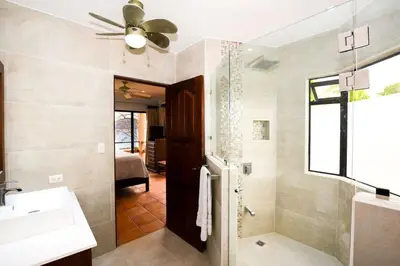 a bathroom with a sink and a ceiling fan at Elegant 3BR Beachfront Condo with Spacious Interior, Ocean-View Terrace & Direct Access to Playa Flamingo in Playa Flamingo